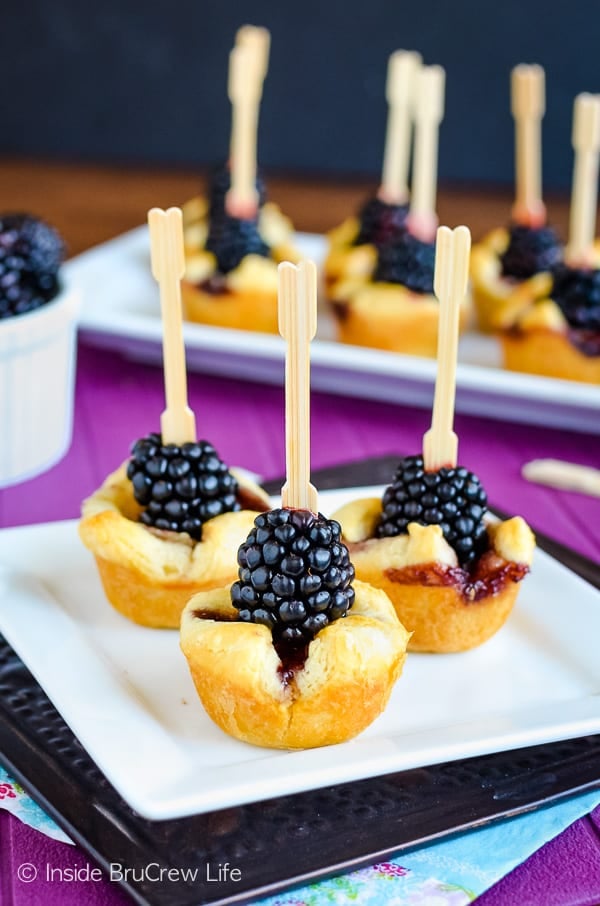 Blackberries skewered on a small crescent mini muffin cup.