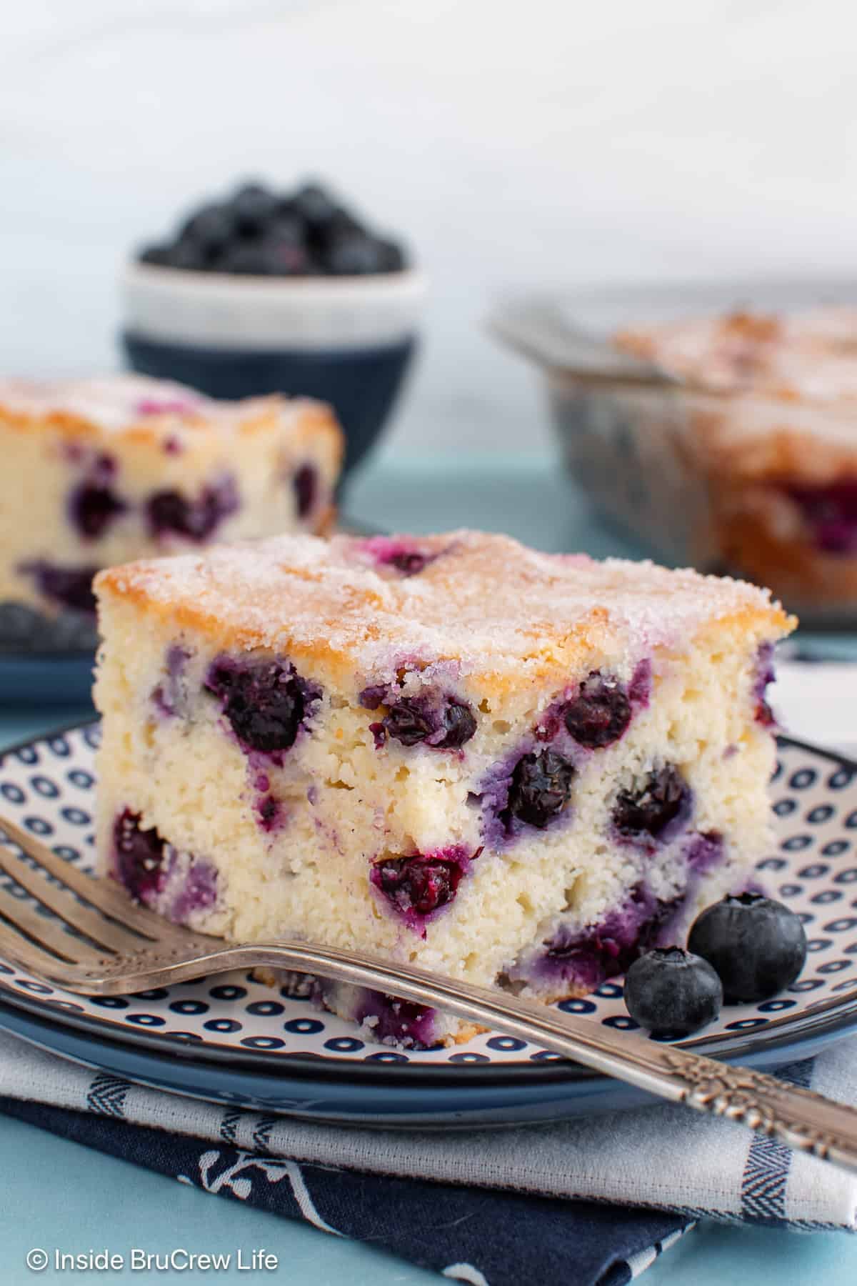 A close up of a piece of blueberry snack cake on a blue plate.