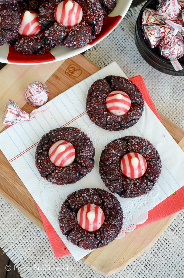 Overhead picture of a white napkin with four chocolate candy cane kiss cookies on it.