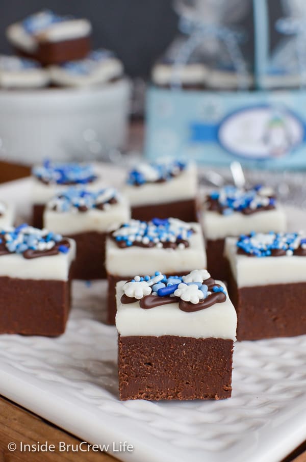 A white plate full of Chocolate Peppermint Fudge with blue and white sprinkles.