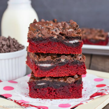 Three red gooey cake mix bars stacked on top of each other.