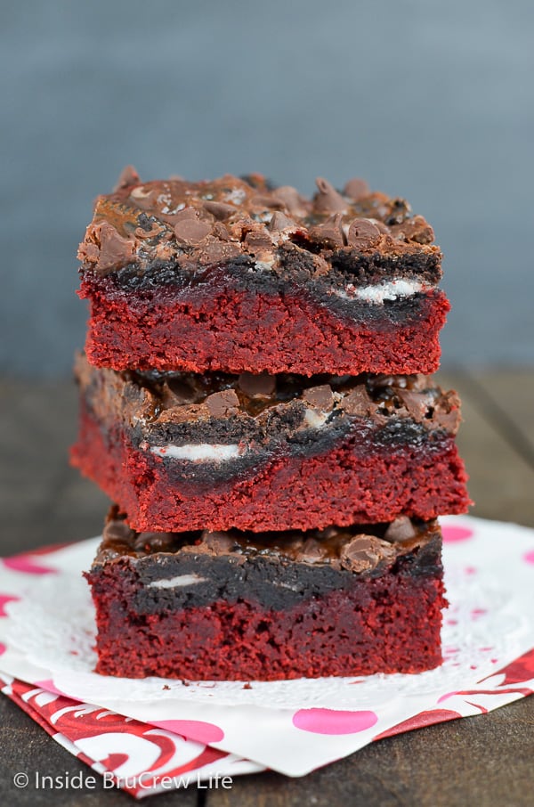 Three red velvet bars with chocolate chips stacked on top of each other.