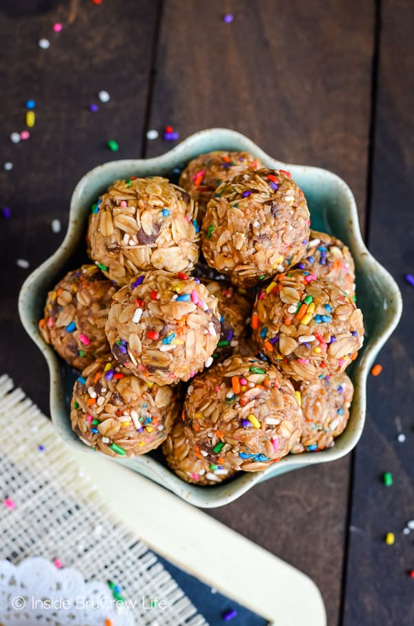 Overhead picture of a bowl of peanut butter granola bites on a brown board