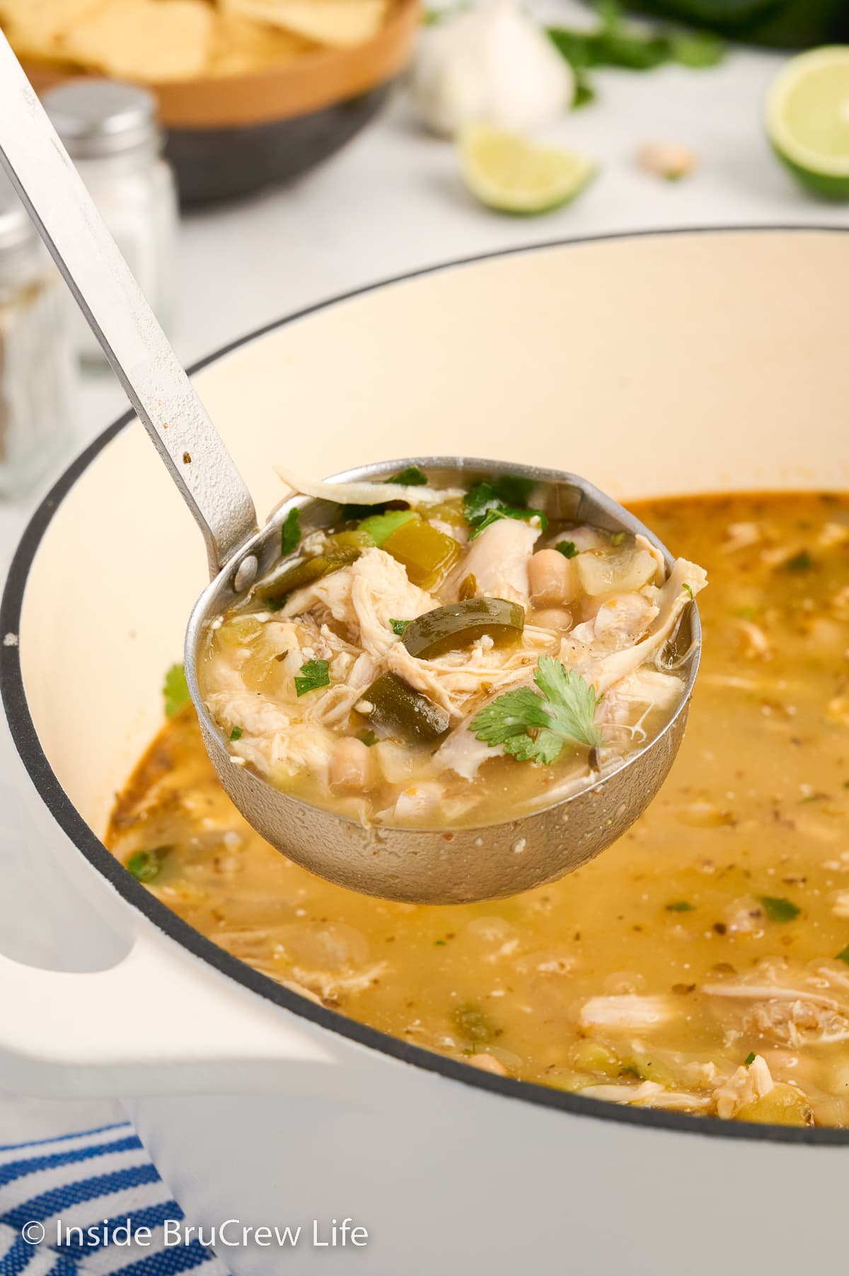 A ladle of soup lifting out of a pot.