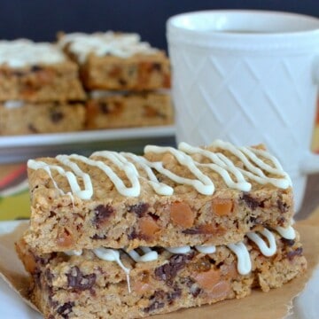 Two white chocolate caramel granola bars stacked on top of it