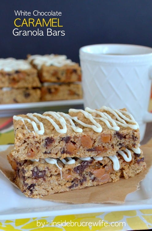 Two white chocolate caramel granola bars stacked on top of each other on a white plate