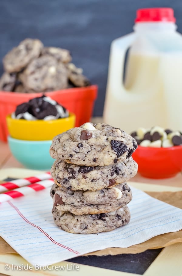 A stack of Oreo cake mix cookies on a white napkin with milk and more cookies behind it.