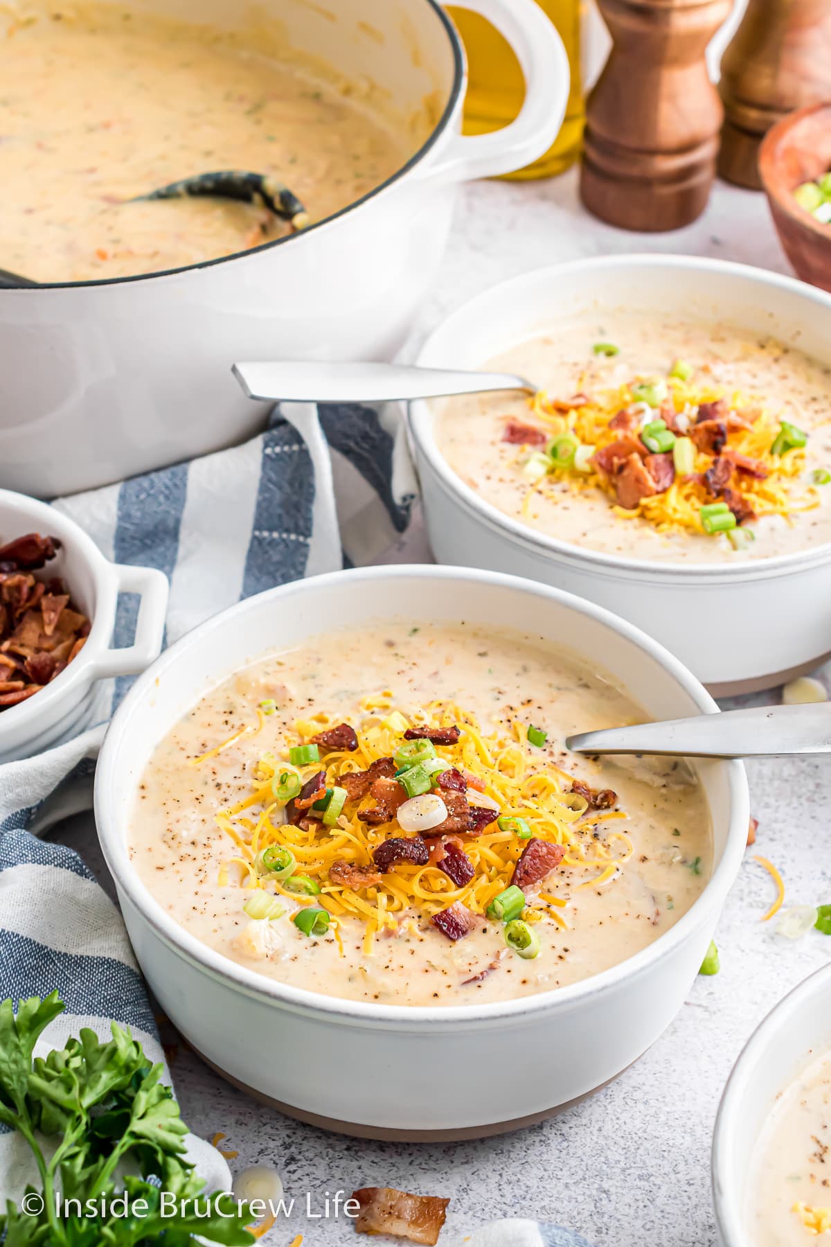 Bowls of loaded potato soup with spoons in them.