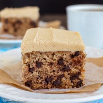 Two white plates with pieces of chocolate chip banana sheet cake on them.
