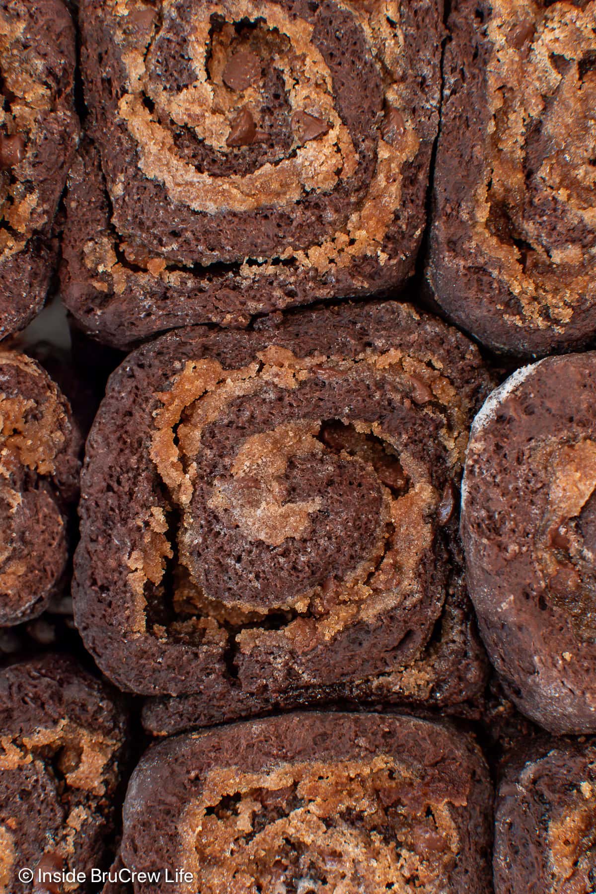 A close up of a chocolate cinnamon roll with melted brown sugar.