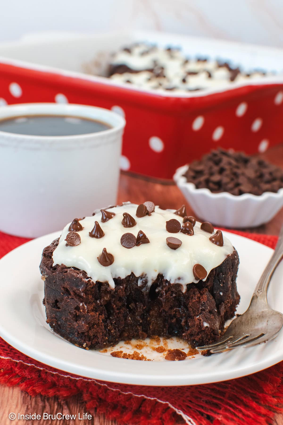 A gooey chocolate cinnamon roll on a white plate.