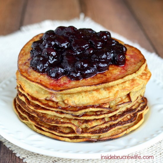 A stack of healthy banana oatmeal pancakes on a white plate with a blueberry sauce on top