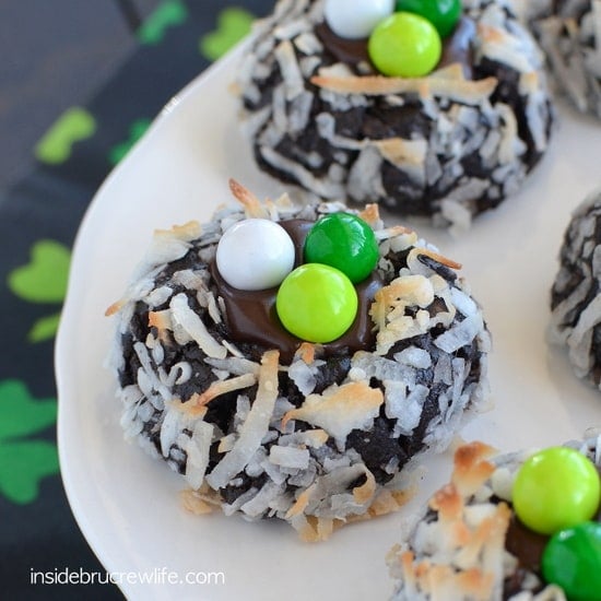 Chocolate cookies with toasted coconut and green candies on them.
