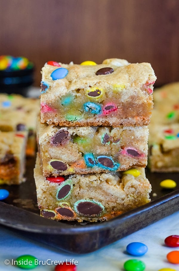 Three blonde brownies stacked on top of each other with lots of M&M's baked in them