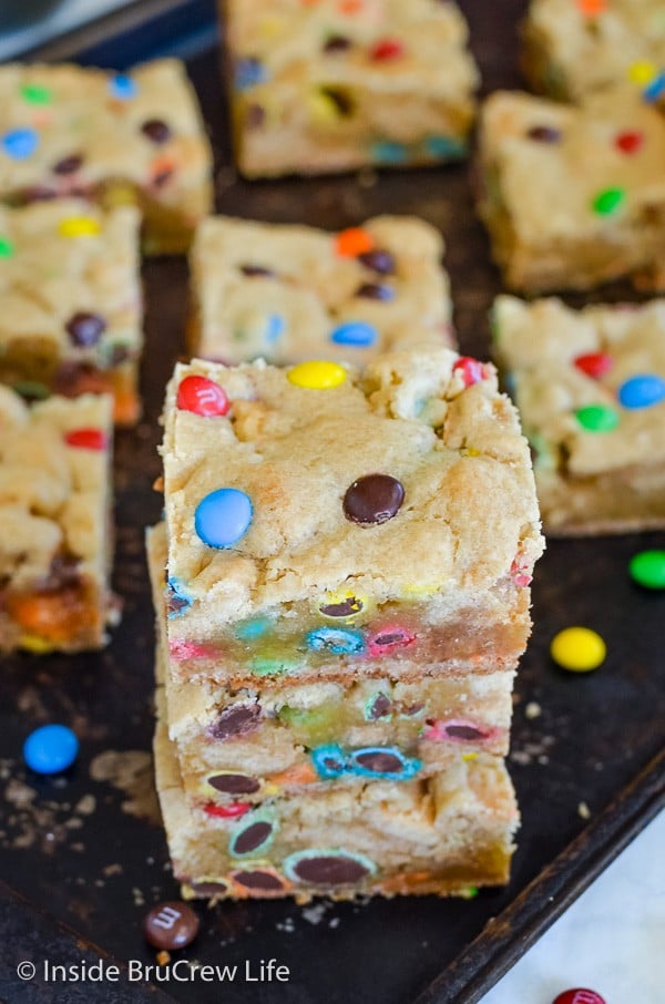 A dark metal tray with squares of M&M Blonde Brownies on it