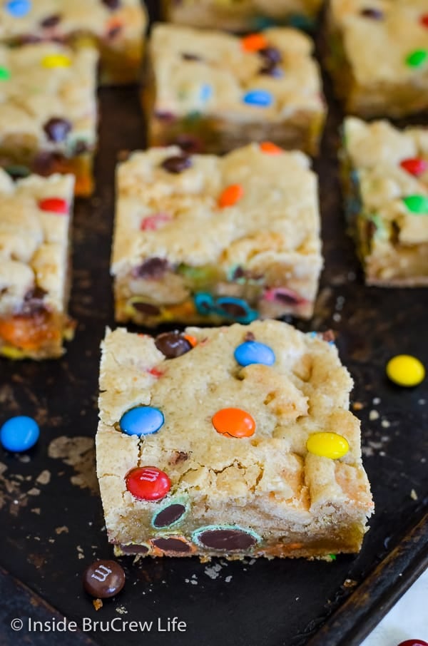 A dark tray with squares of M&M Blonde brownies on it