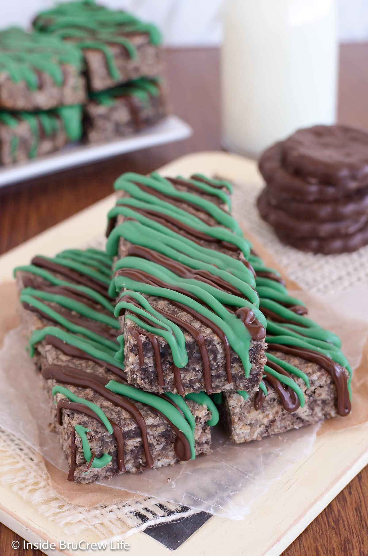 A pile of chocolate granola bars with green chocolate drizzles.