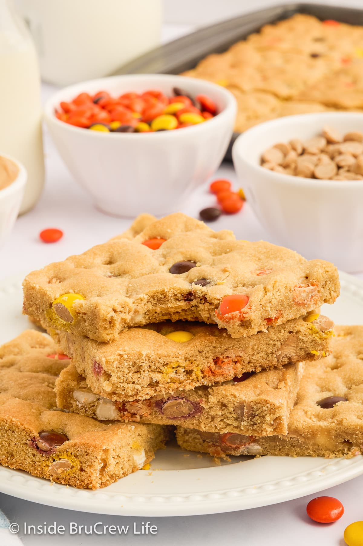 A stack of peanut butter bars on a white plate.