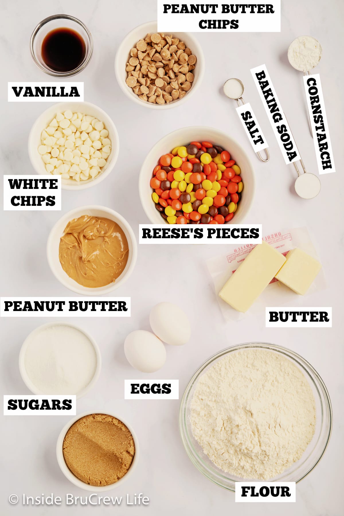 A white board with bowls of ingredients needed to make cookie bars.