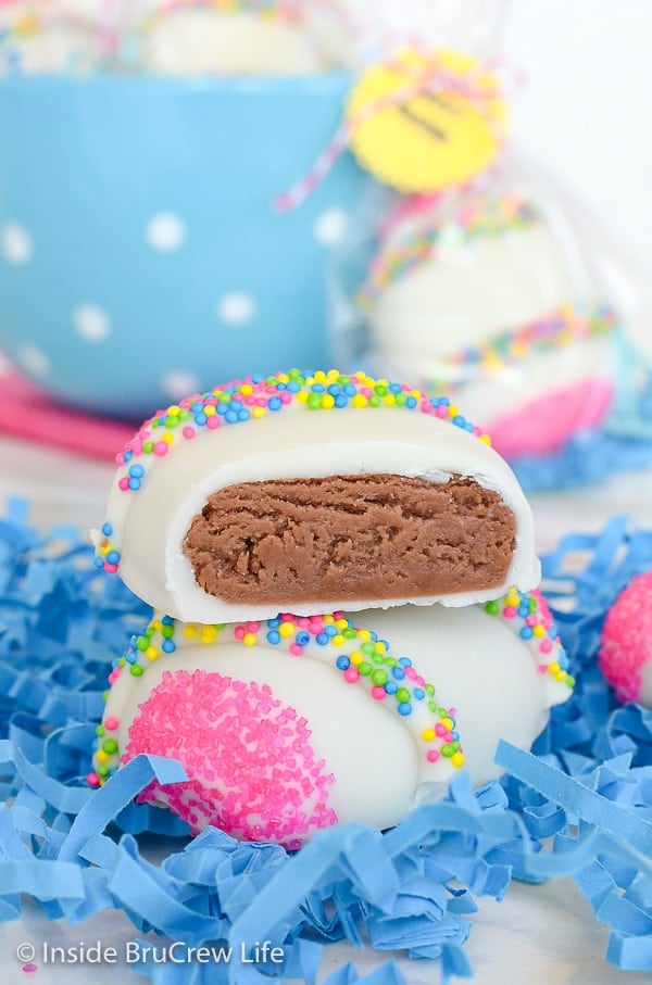 A white chocolate covered egg with half of a Nutella egg on half surrounded by blue filler paper.
