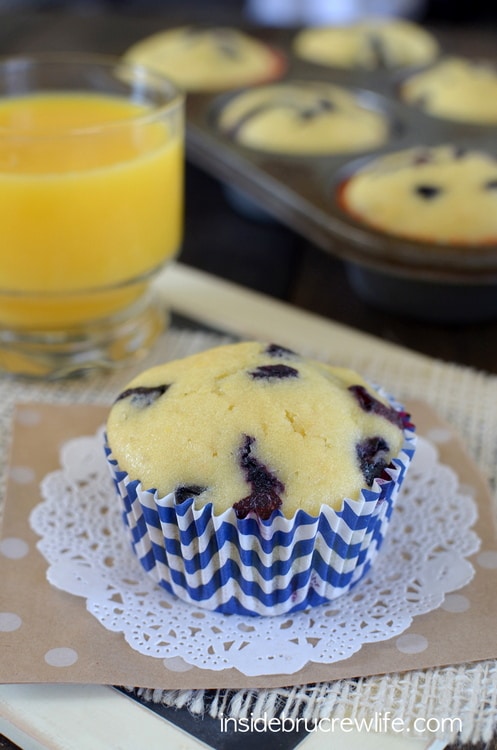 A blueberry muffin on a blue liner.