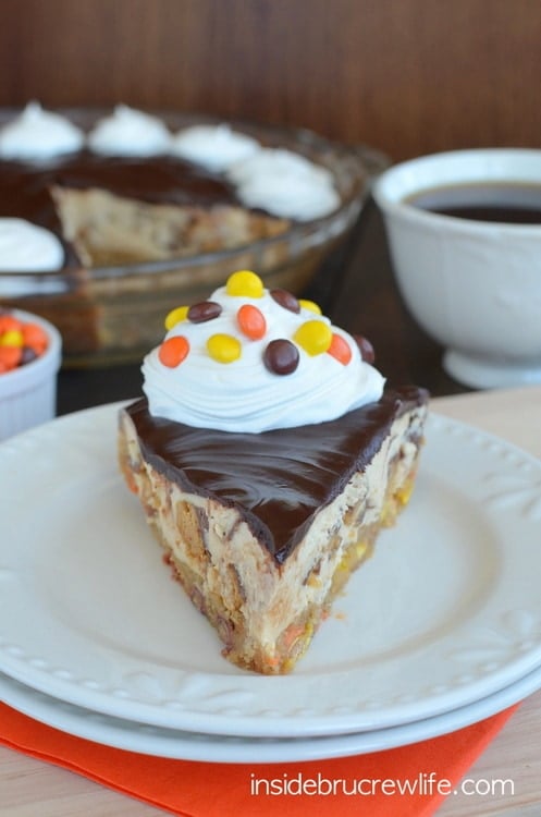 A slice of peanut butter cookie pie on a white plate with the pie plate behind it