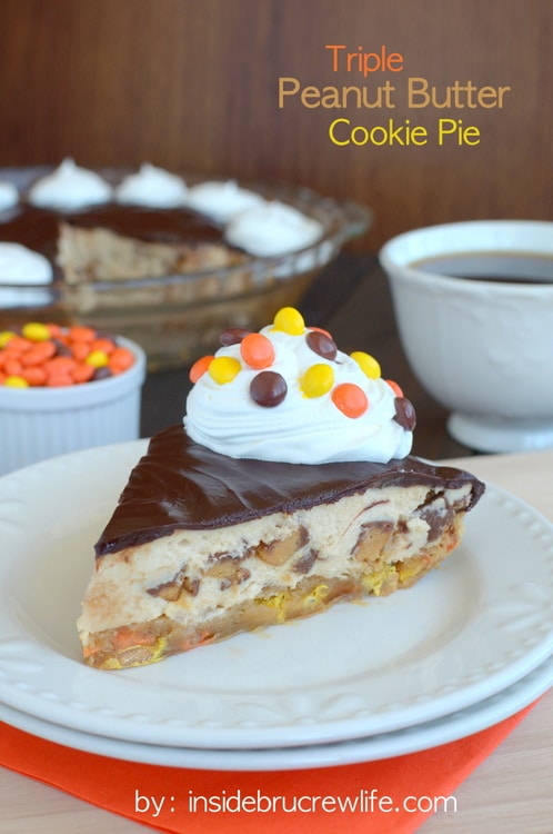 A slice of peanut butter cookie pie topped with chocolate, whipped cream, and peanut butter candies on a white plate