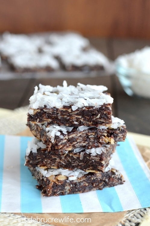 A stack of four almond joy energy bites on a blue and white striped paper