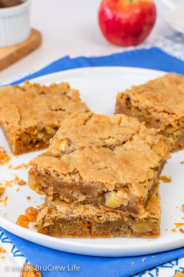 A white plate with squares of butterfinger apple blondies on it.