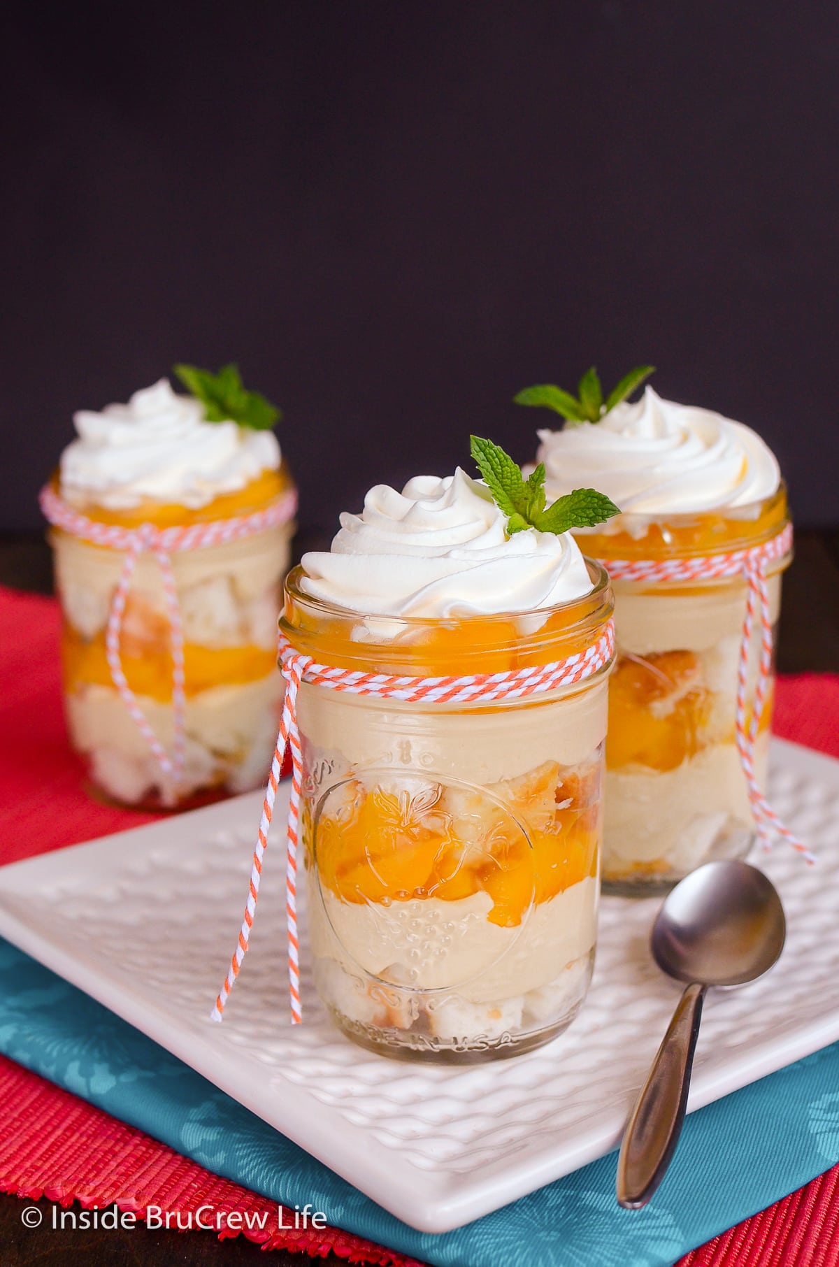 Three cheesecake dessert cups layered with pie filling.