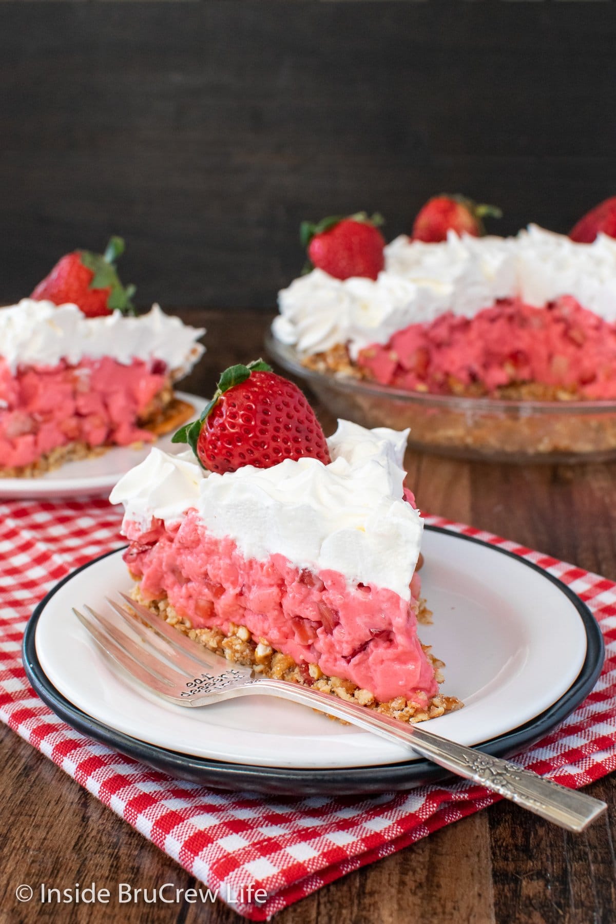 A white plate with a slice of strawberry pie on it.