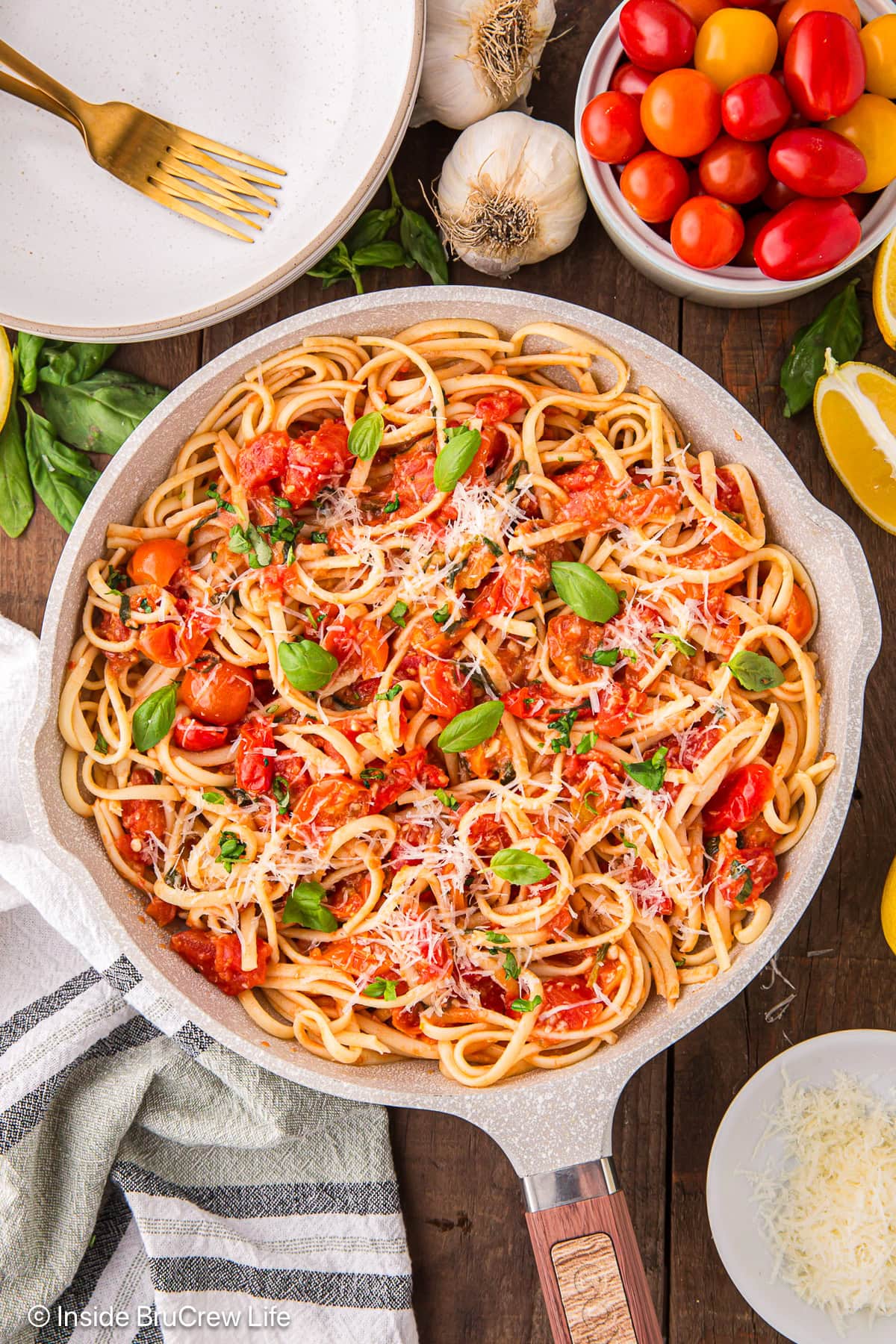 A skillet filled with tomatoes and pasta.