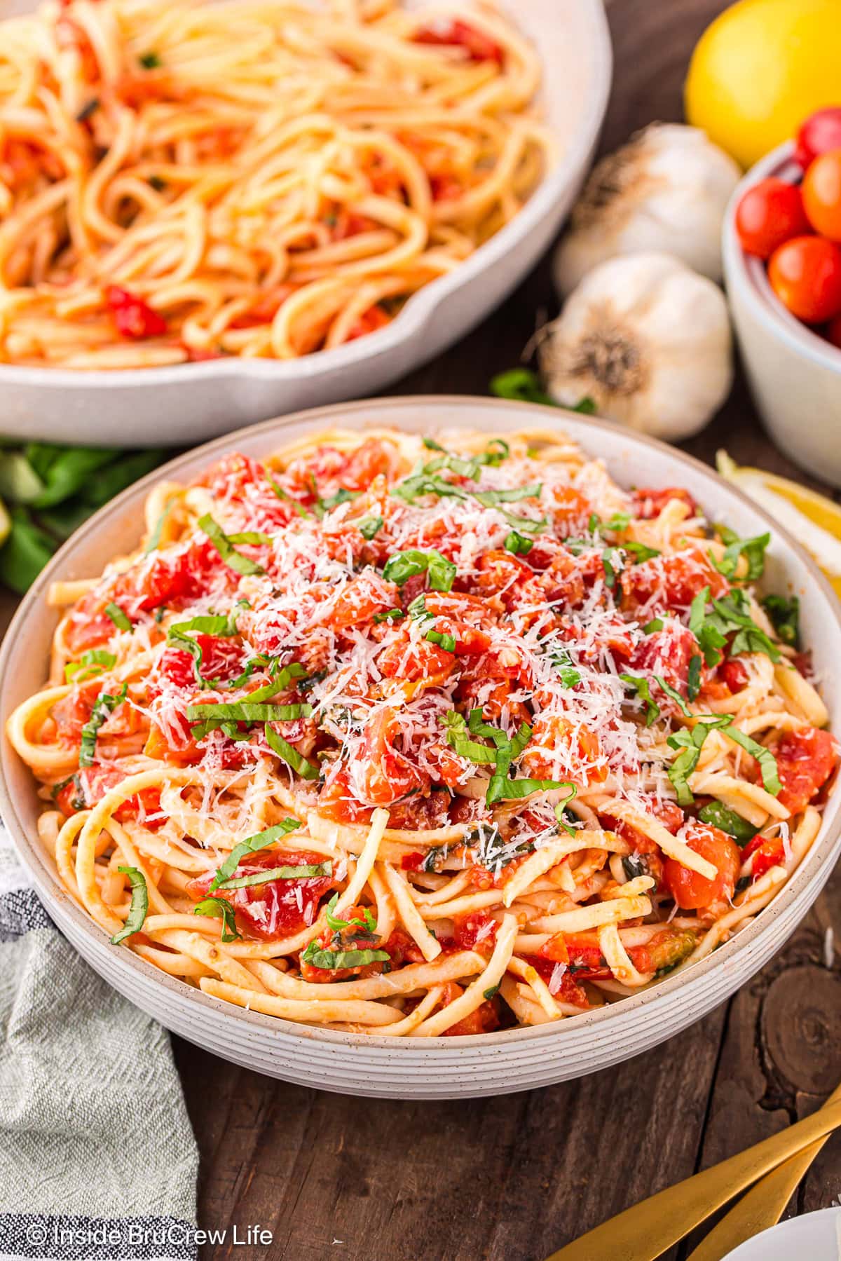 A bowl of tomato basil pasta topped with grated cheese.