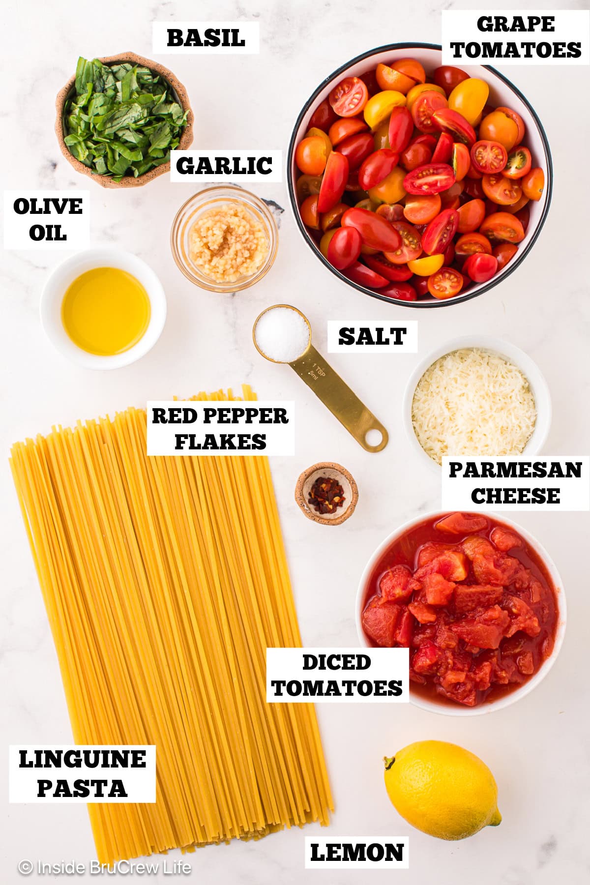 Bowls of ingredients needed to make basil pasta with fresh tomatoes.