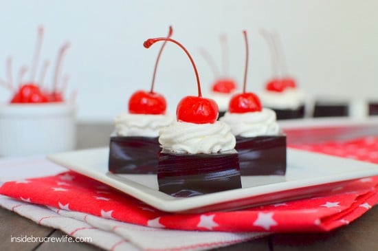 A white plate with Jello squares topped with cool whip on it.