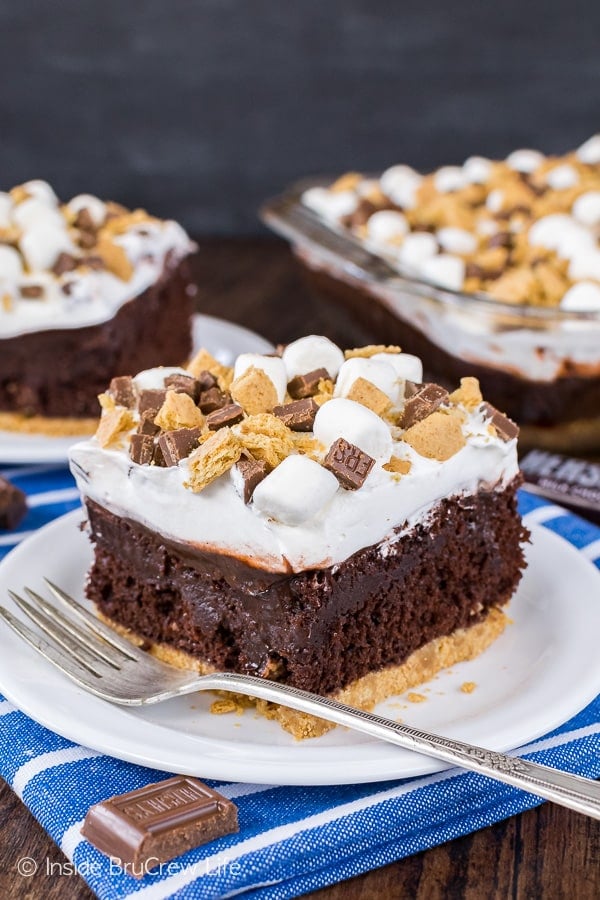 A close up picture of a white plate with a piece of chocolate s'mores pudding cake on it