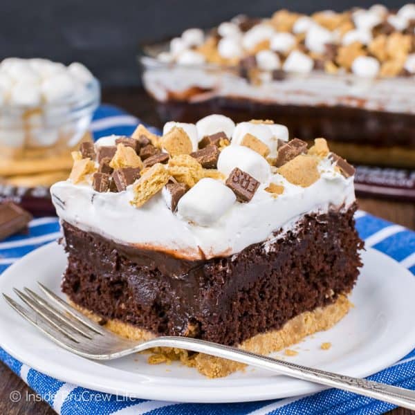 A square photo of a white plate with a square of chocolate s'mores pudding cake