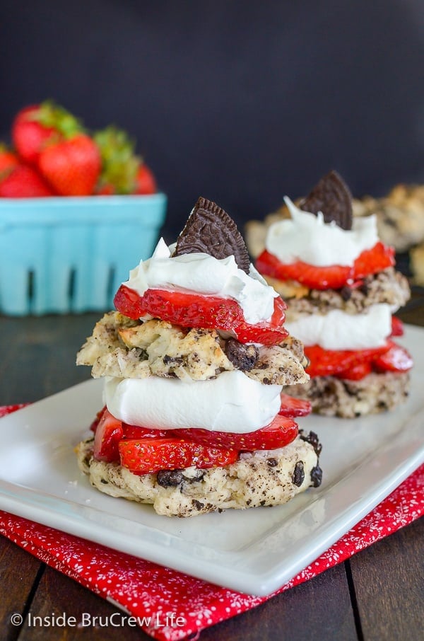 A white plate with two stacks of Coconut Oreo Strawberry Shortcakes layered with whipped cream and strawberries