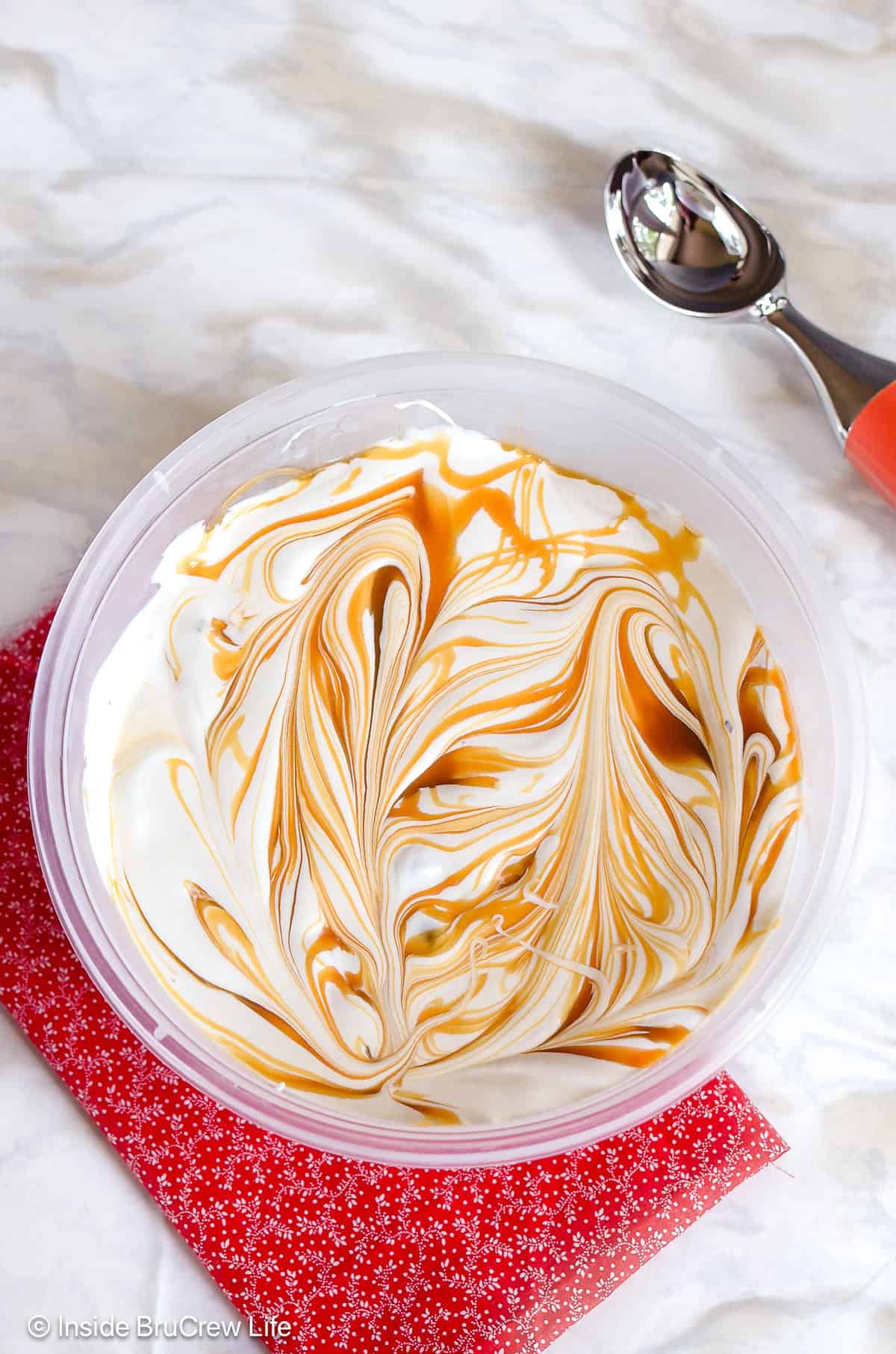 A bowl of Snickers ice cream with caramel swirls.