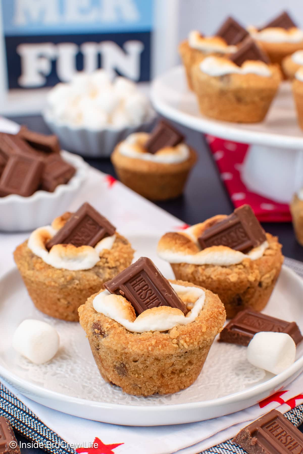 Three s'mores cookie cups on a white plate.