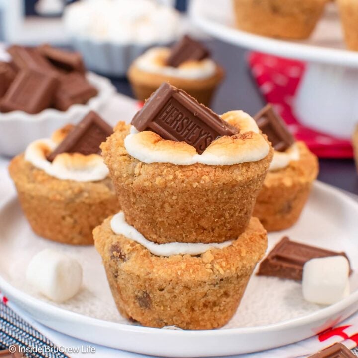 Little cookie cups topped with s'mores toppings on a white plate.