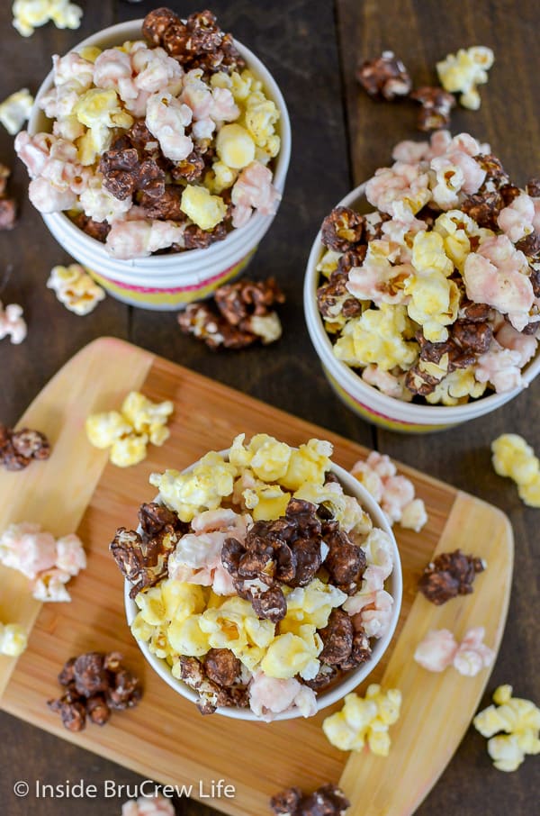 Overhead picture of three bowls of banana split popcorn on a wood background