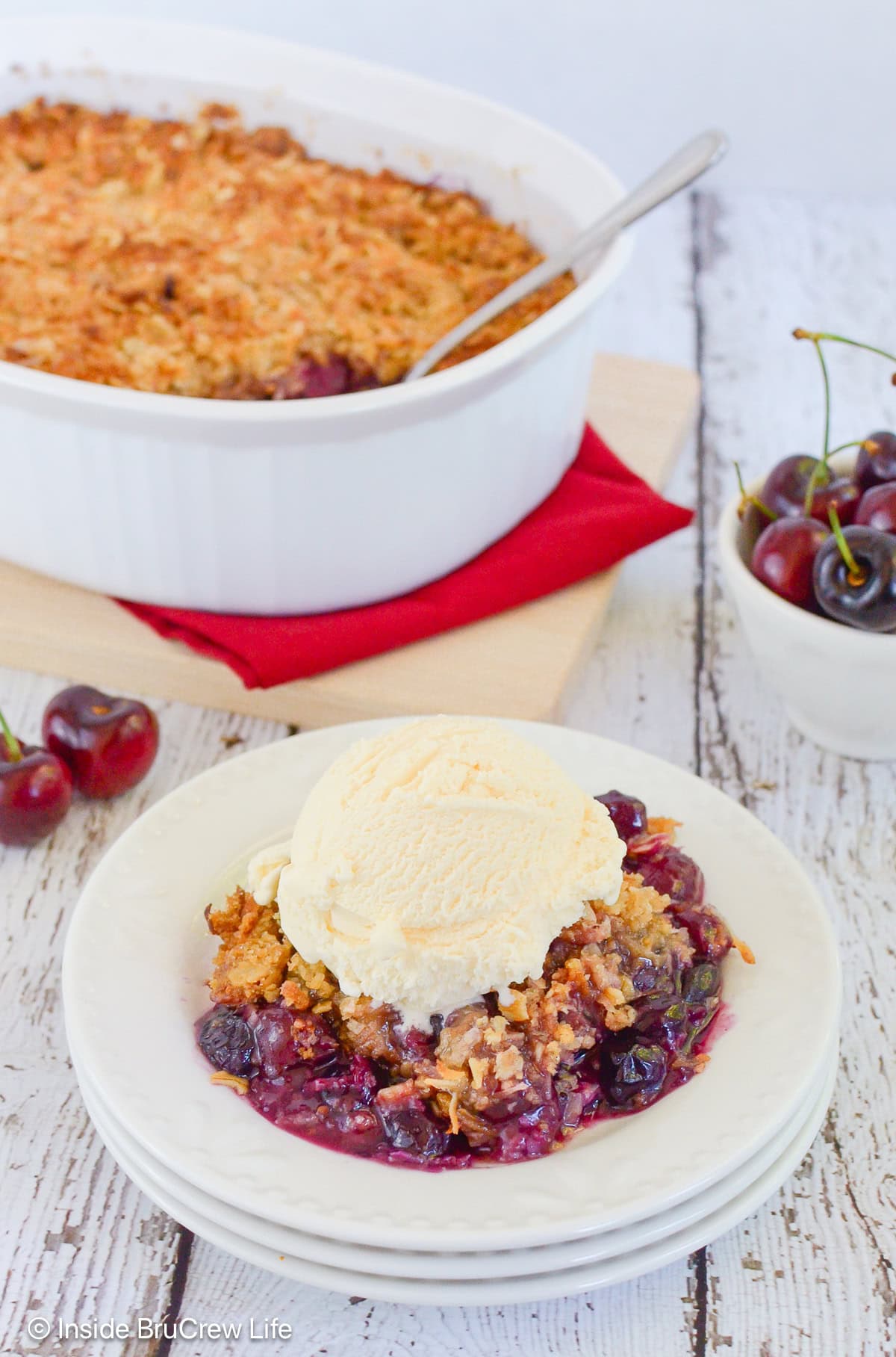 A stack of bowls filled with fruit crisp and ice cream.