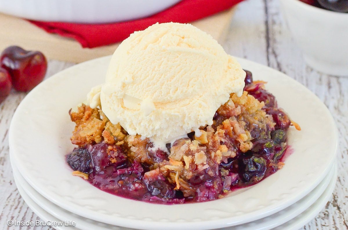 A bowl of fruit crisp and ice cream.