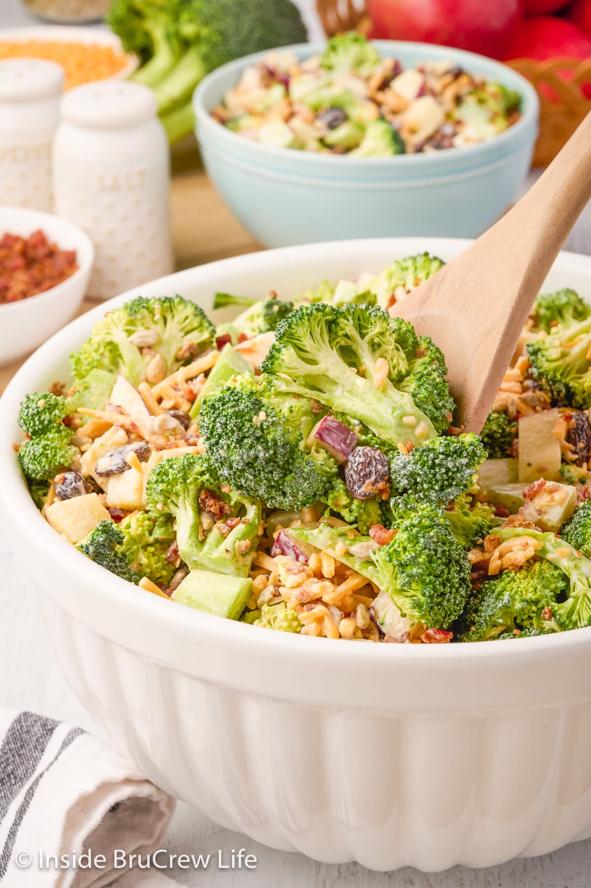 A large white bowl filled with broccoli salad.