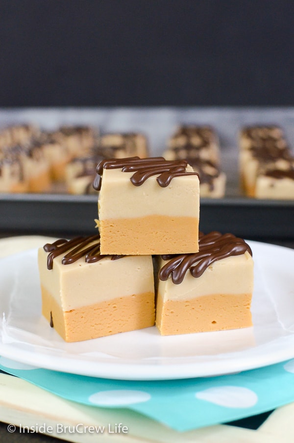 A white plate with three fudge squares stacked on it.