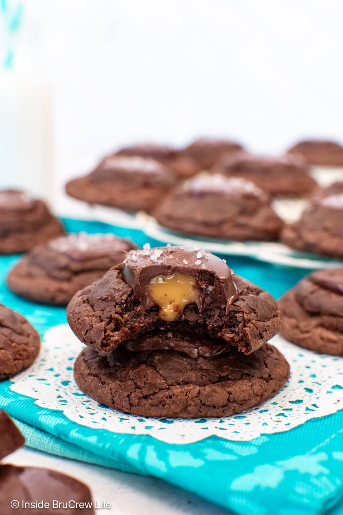Two stacked salted caramel brownie cookies with a bite out of the top one.