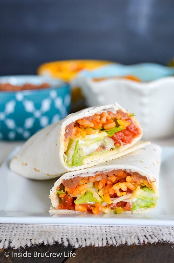 Two halves of Seven Layer Burritos on a white plate