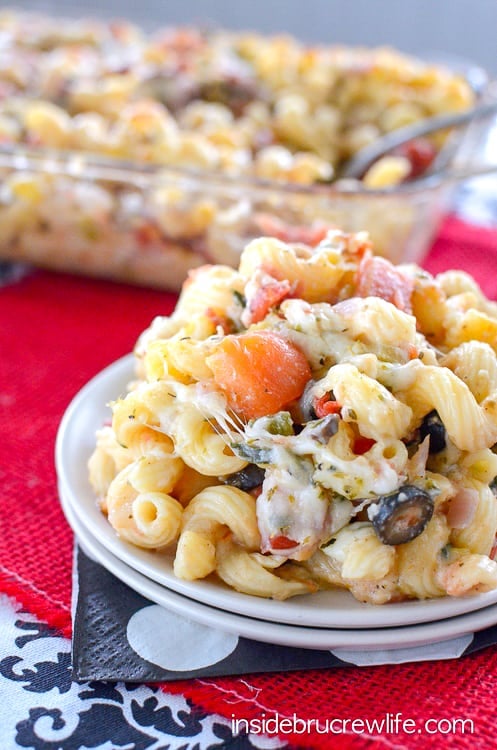 Close up picture of a white plate filled with cheesy veggie pasta