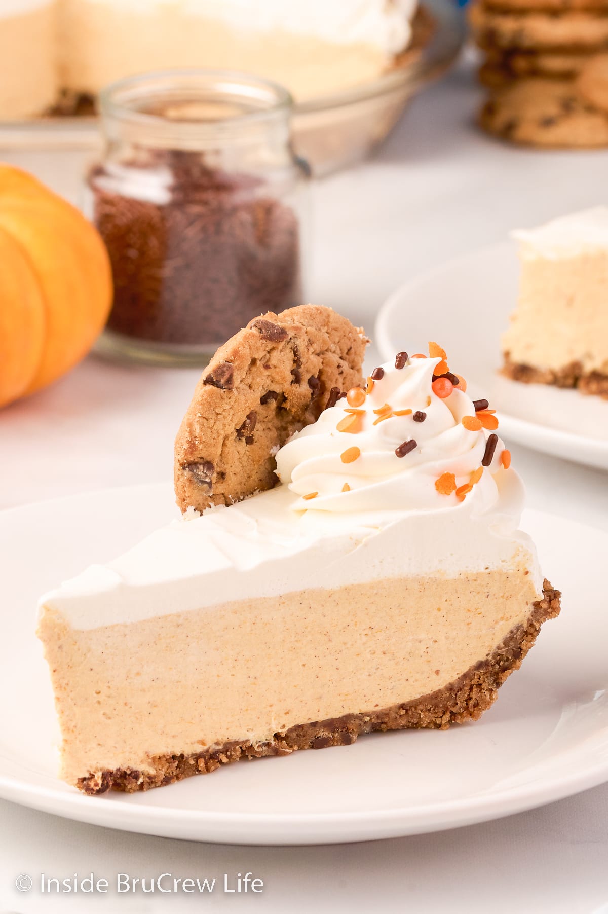 A slice of no bake pumpkin cheesecake on a white plate.